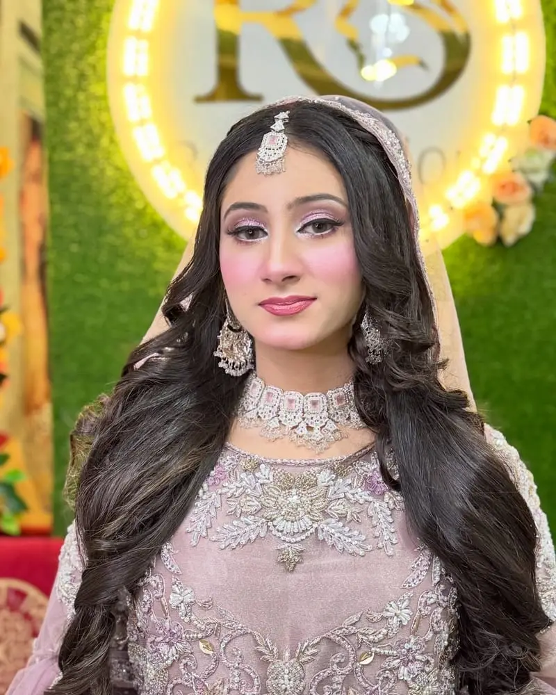 Bride in lilac with soft pink makeup, a diamond necklace and long waves