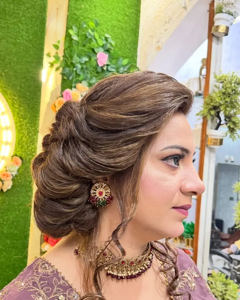 Side view of a voluminous textured bun with face-framing curls