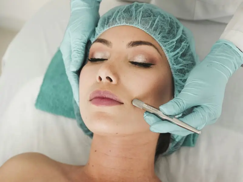 Client receiving a facial treatment from a therapist in gloves