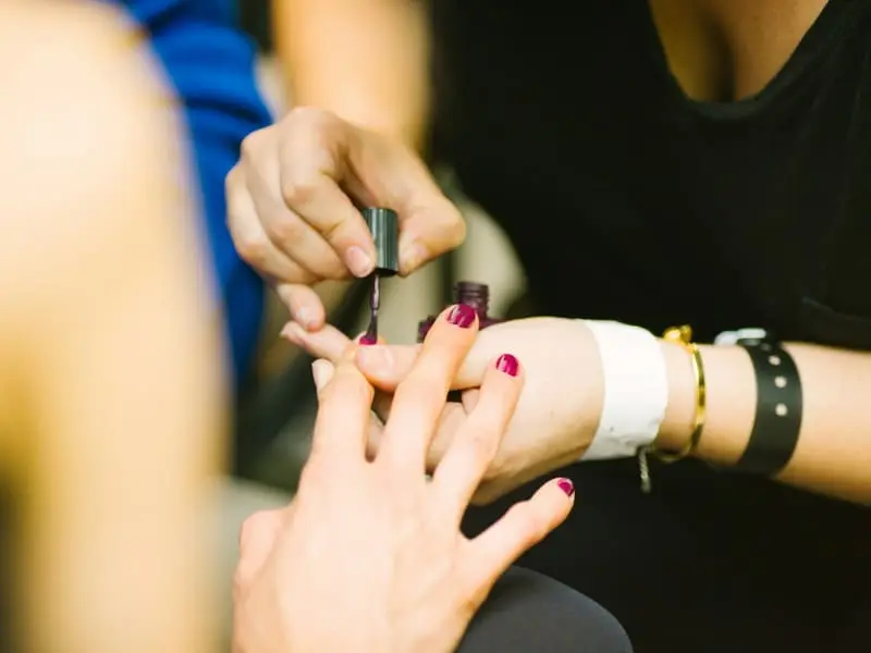Nail technician applying polish during a manicure