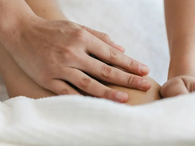 Therapist giving a relaxing massage over a white towel